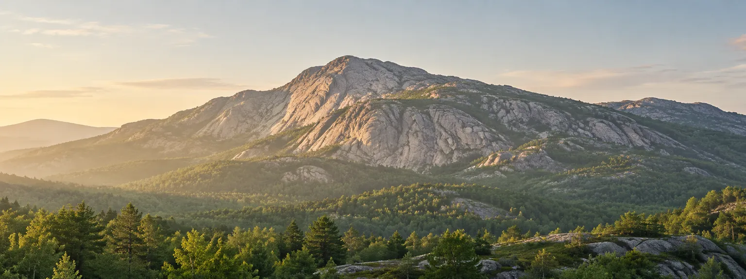 Weathered mountain rock above green foothills